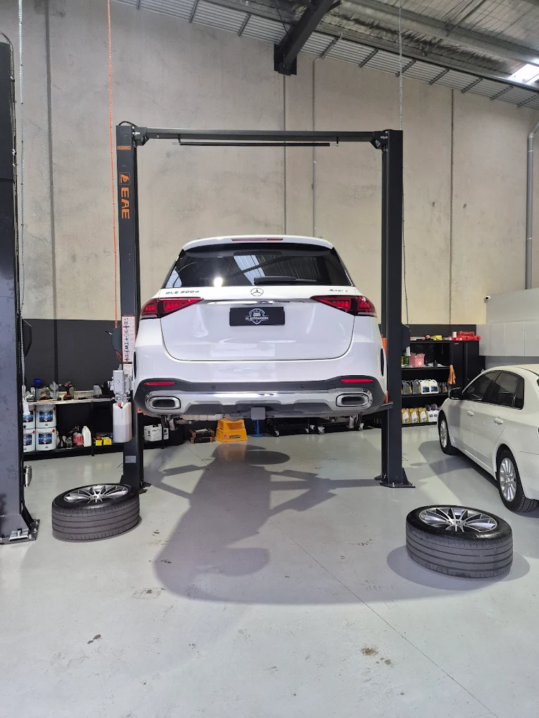 Mercedes-Benz vehicle elevated on a hydraulic lift in a professional garage