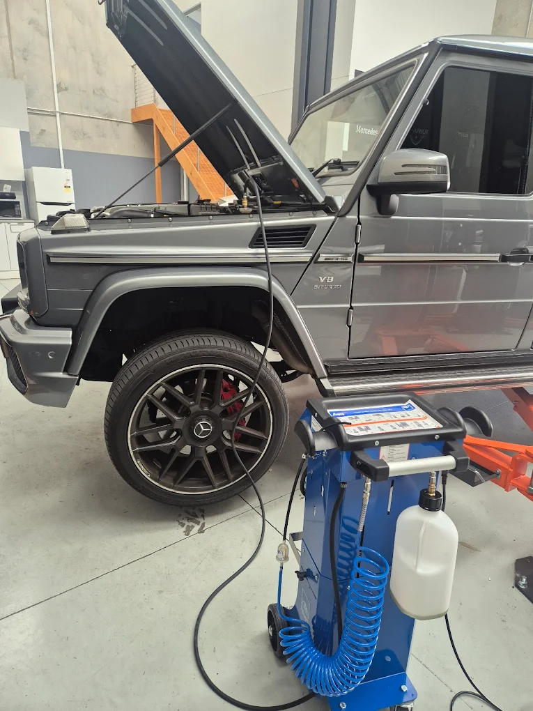 Mercedes-Benz G-Class SUV with open hood in a garage